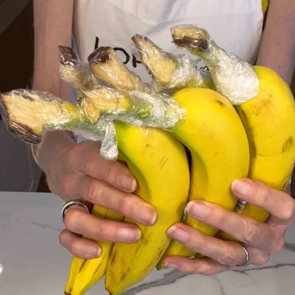 Separate your bananas and wrap each top with plastic- this slows down the